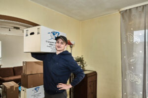 Umzugskarton von der Spedition Transporte und Umzüge Miller mit einem Mitarbeiter der Firma