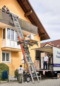 ein Möbelstück wird mit einem Schrägaufzug über den Balkon transportiert