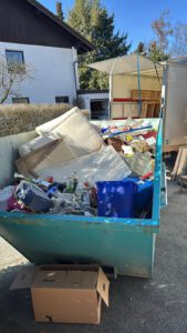 container voller müll nach einer entrümpelung